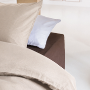 Bed opgemaakt met 100% Egyptisch katoen, bruin hoeslaken, beige dekbedovertrek, beige kussensloop, wit kussensloop