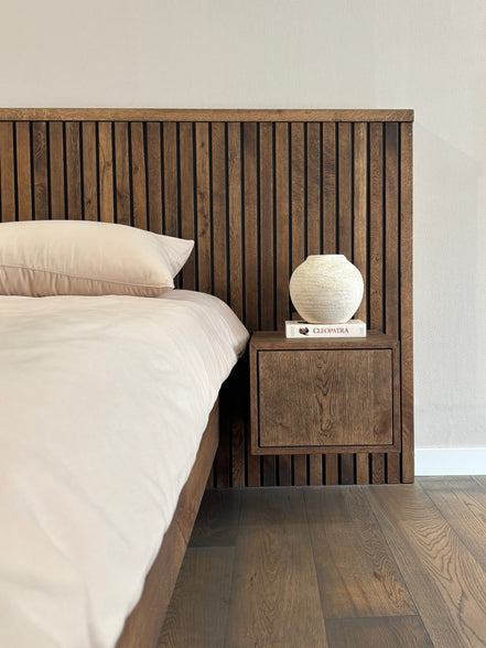 Massief houten bed wat perfect aansluit bij japandi interieur met beige beddengoed van Egyptisch katoen