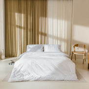 japandi slaapkamer met opgemaakt bed