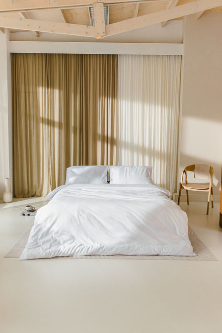 japandi slaapkamer met opgemaakt bed