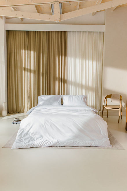 japandi slaapkamer met opgemaakt bed