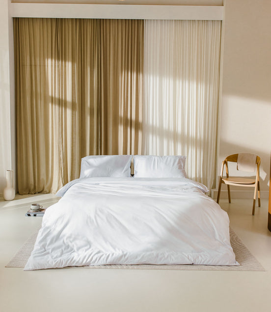 japandi slaapkamer met opgemaakt bed