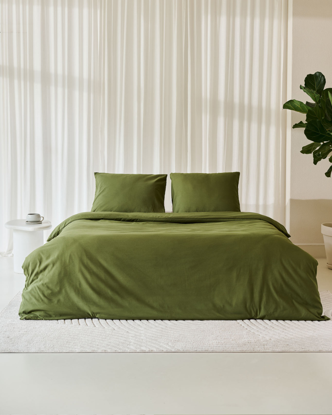 rustige slaapkamer met opgemaakt bed met groen beddengoed van egyptisch katoen 400TC