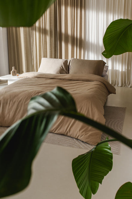 egyptisch katoen opgemaakt bed in slaapkamer met een plant